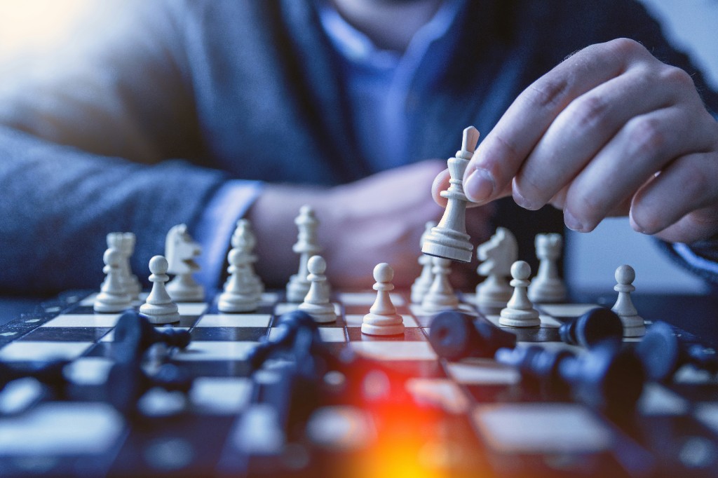 Enterprise software consumer habits article cover: hand moving a white chess king